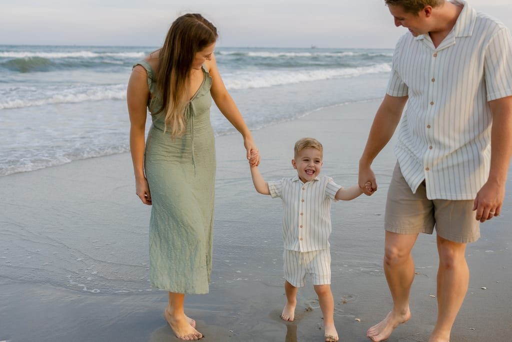 Family walking along the shoreline during sunset in Atlantic Beach, North Carolina.