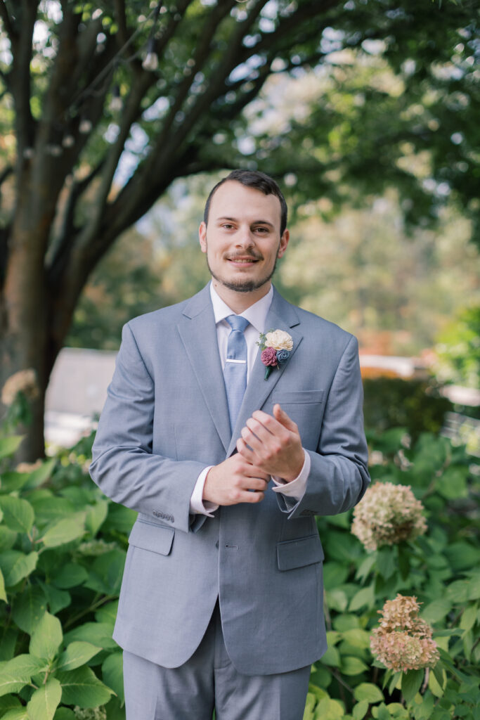 A groom adjusts his suit during his intimate elopement in France