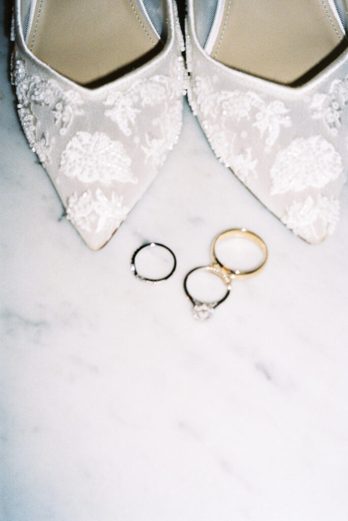 Designer shoes with a oval cut diamond ring on marble at an intimate European wedding