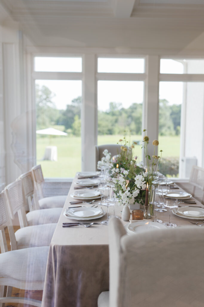 Editorial wedding tablescape with modern glassware, candlelight, and florals by Florals by Heritage