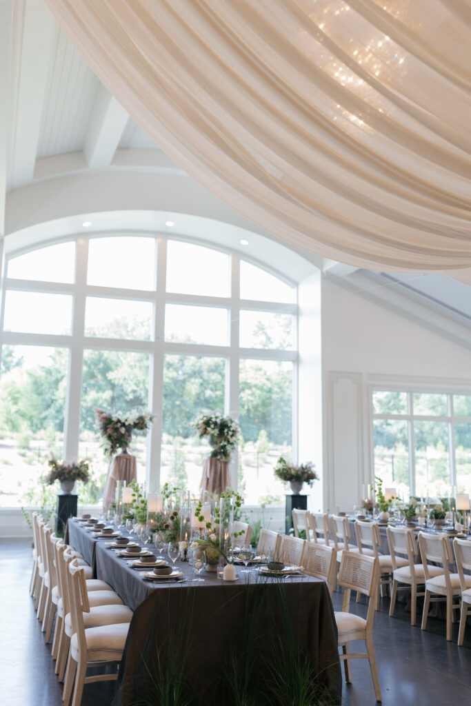 Candlelit reception detail with layered dinnerware and natural floral accents