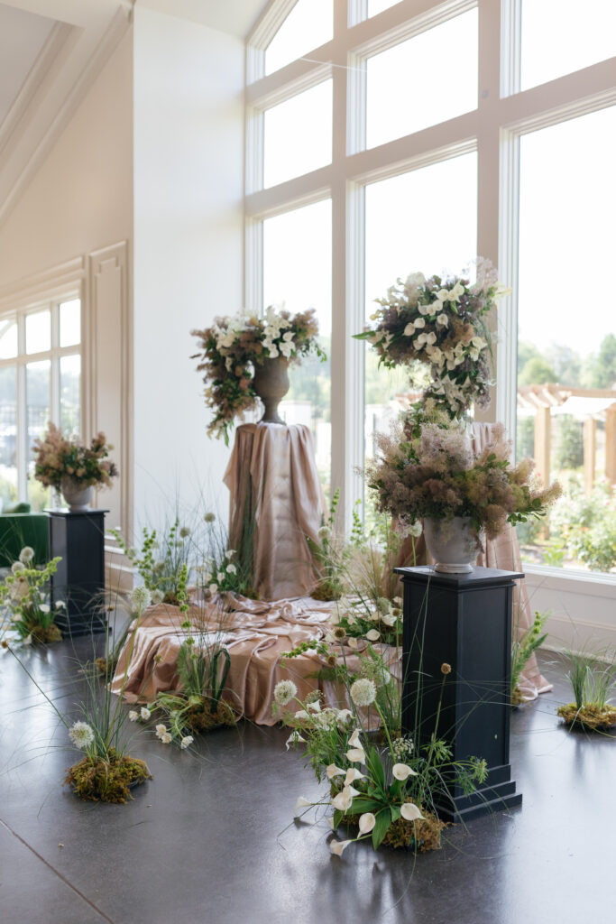 A large sculpture floral installation surrounds the ceremony during a wedding at Donovan Manor