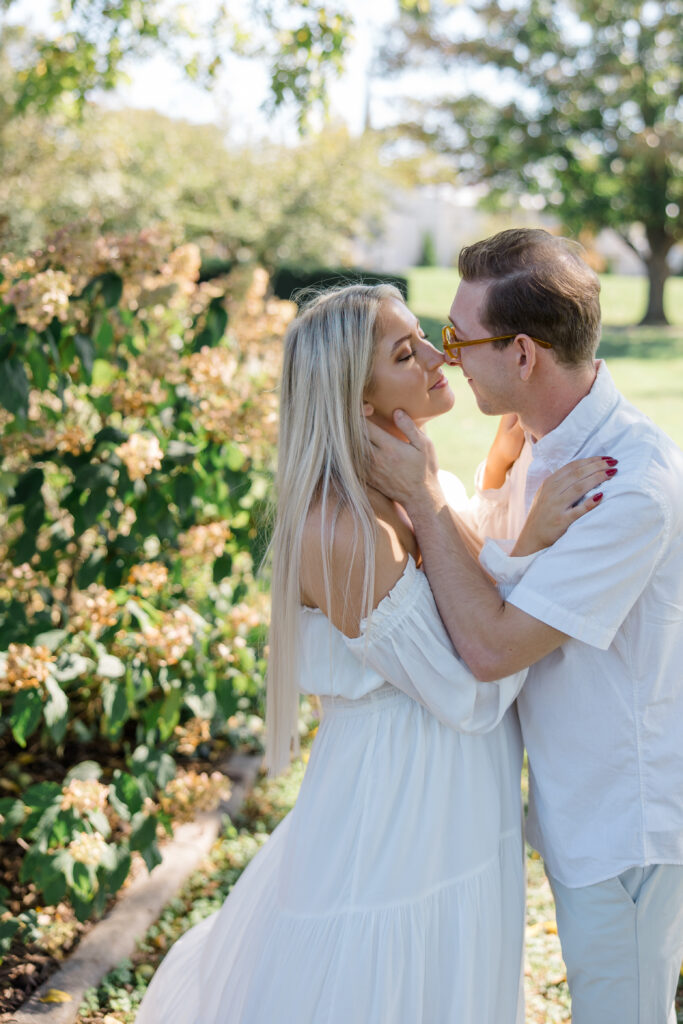 Couple sharing an intimate moment surrounded by hydrangeas at Baker Park