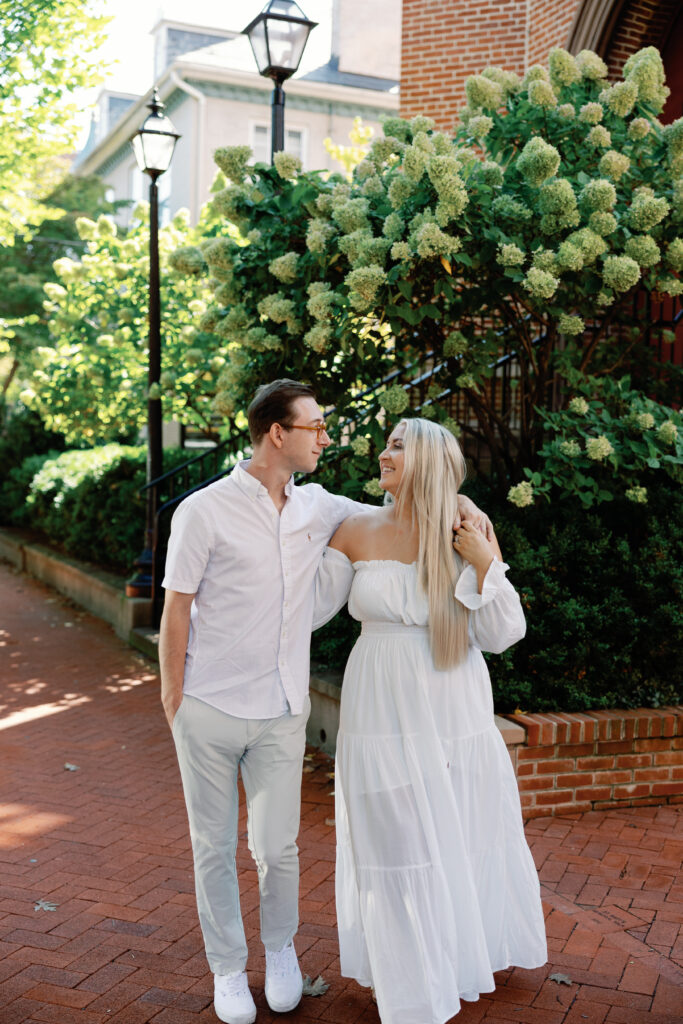 Couple laughing together surrounded by summer hydrangeas in Downtown Frederick