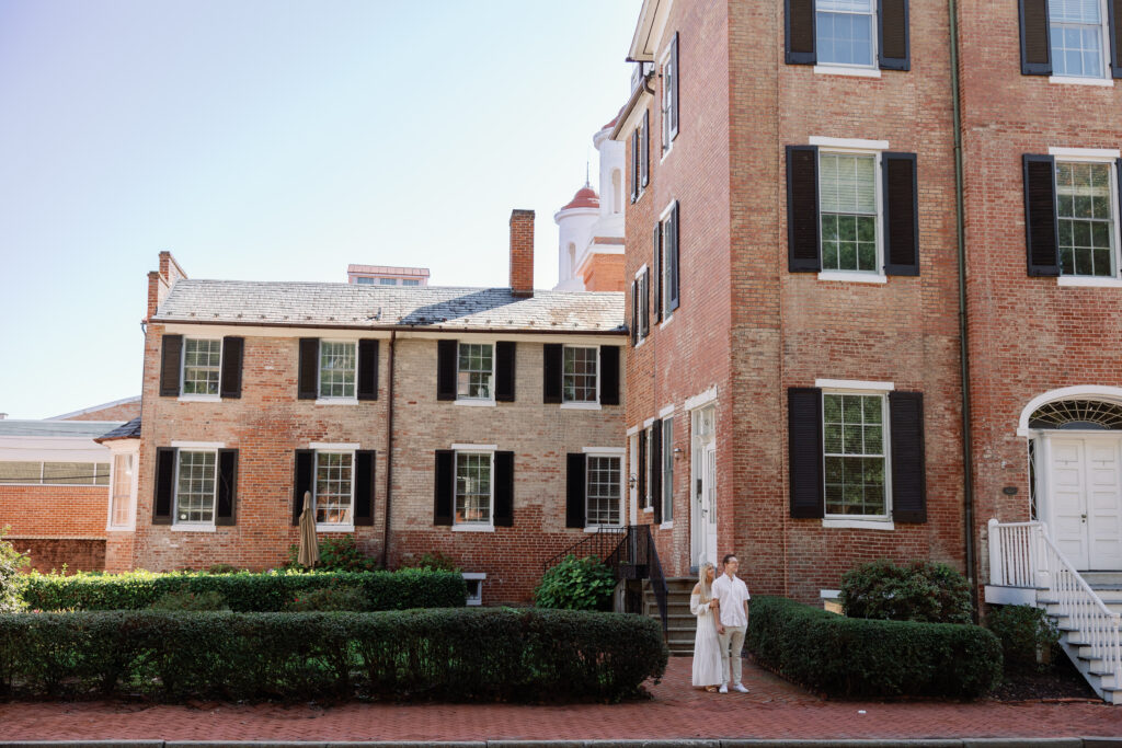 Couple standing close together near historic architecture in Downtown Frederick