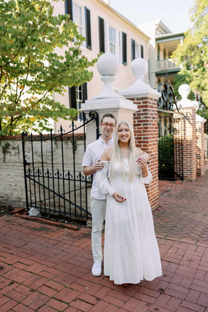 Historic home backdrop with couple embracing outside during Frederick engagement photos