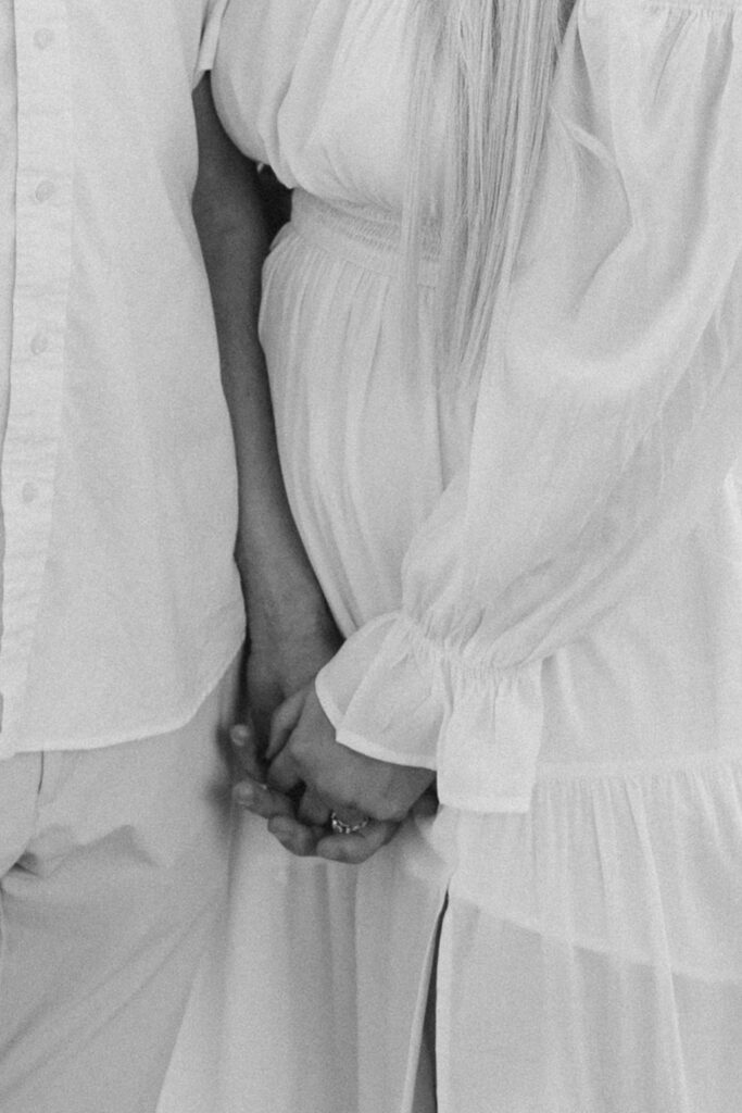 Close-up of couple holding hands showing engagement ring during Frederick engagement session