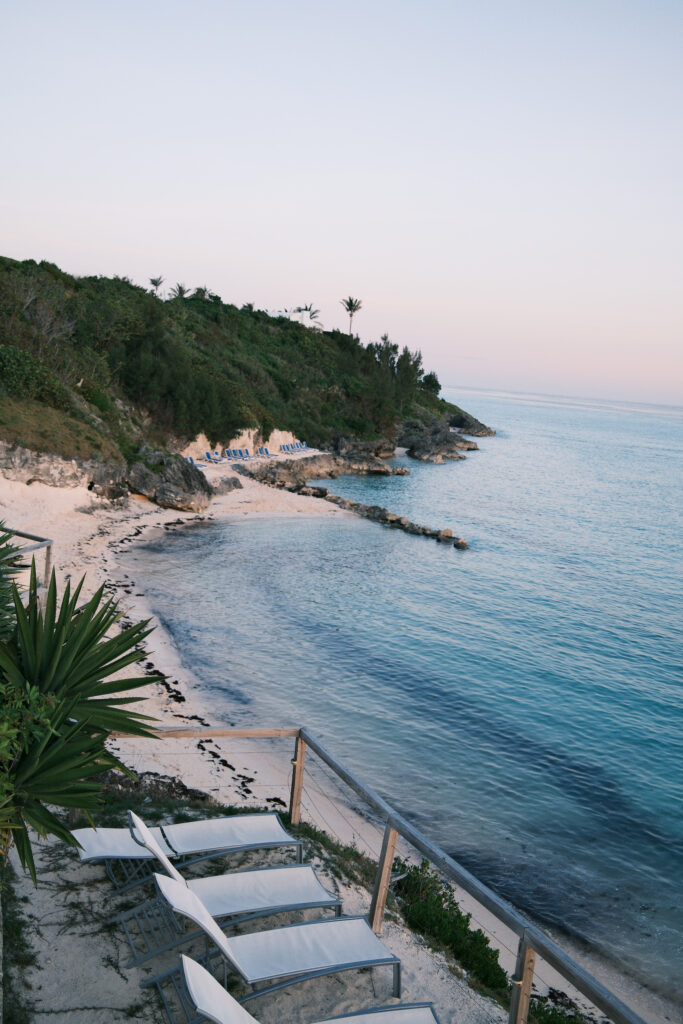 Golden light spilling over lush greenery and coral rock near Bermuda’s coastline