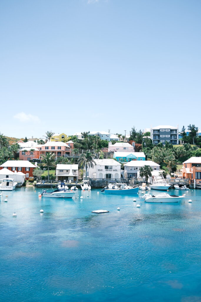 Pastel Bermuda homes with bougainvillea in bloom overlooking turquoise bay.