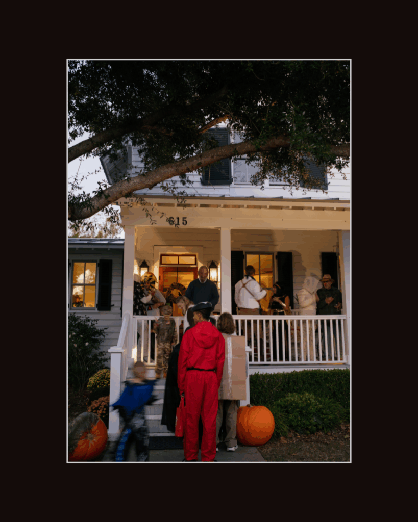 Children and families trick-or-treating in Beaufort North Carolina at a white historic home decorated for Halloween — photographed by Beaufort NC photographer Hailey Rae.