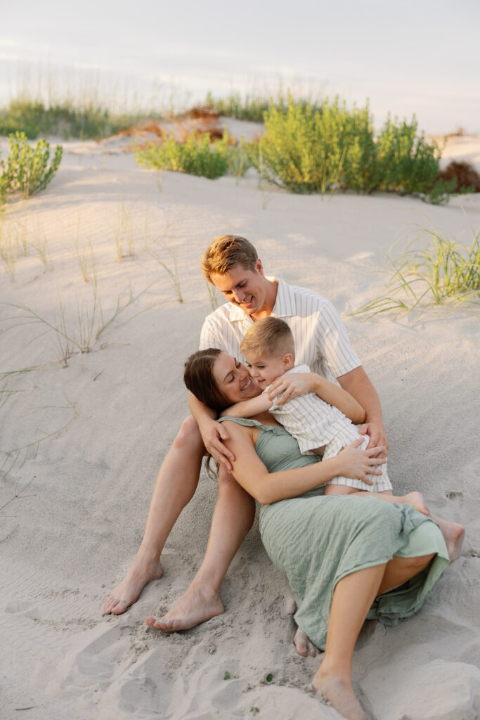 Candid family hug captured at sunset on the dunes by an Atlantic Beach family photographer.