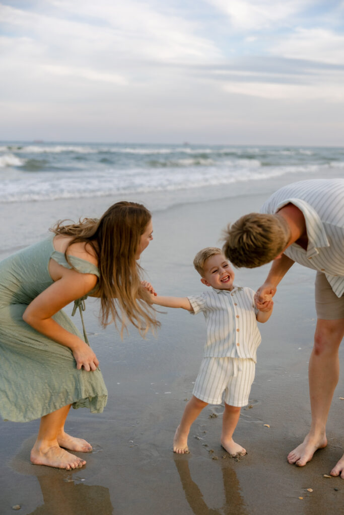 Parents holding hands while watching the sunset on Atlantic Beach, NC.