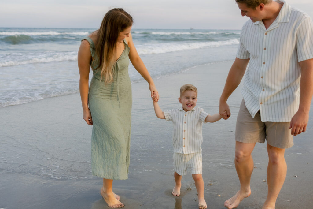 Family walking along the shoreline during sunset in Atlantic Beach, North Carolina.