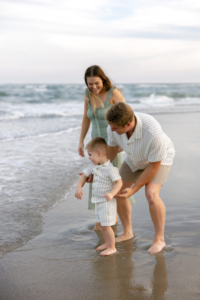 A mom and dad play with their son along the banks of Atlantic Beach, NC. 