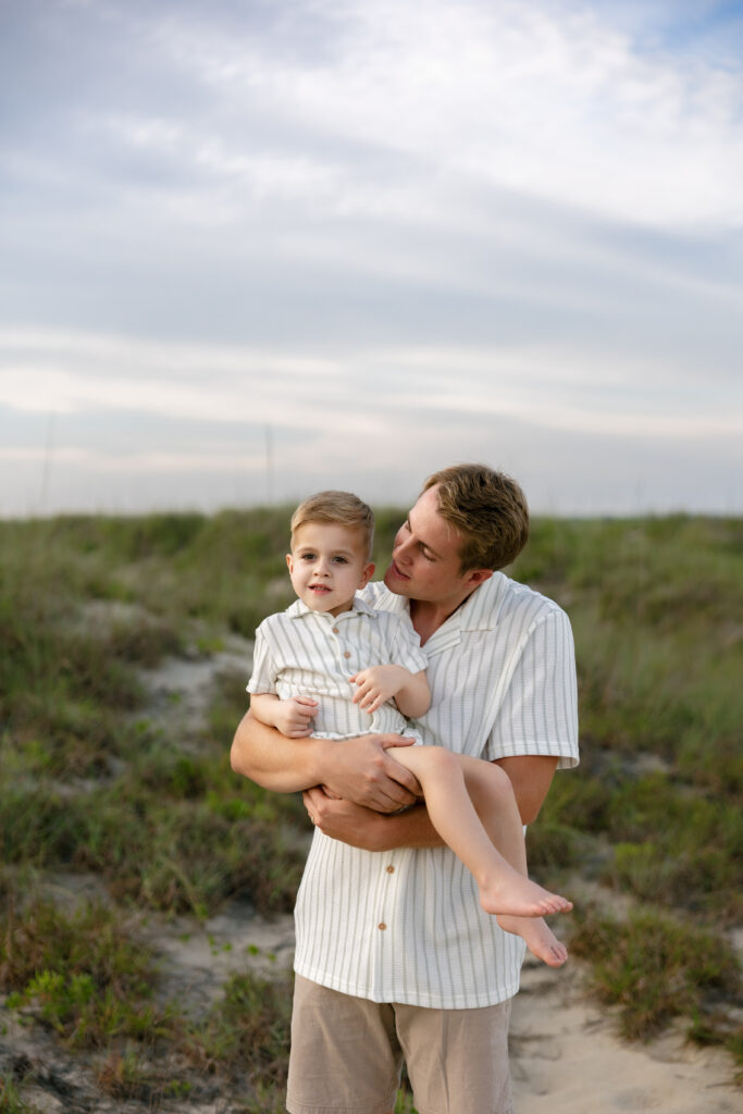 A father holds his son during family portraits at Fort Macon State Park. 
