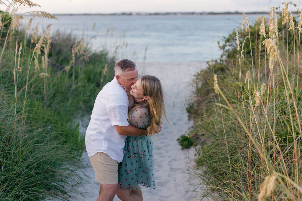 Newly engaged couple embracing at Fort Macon Beach