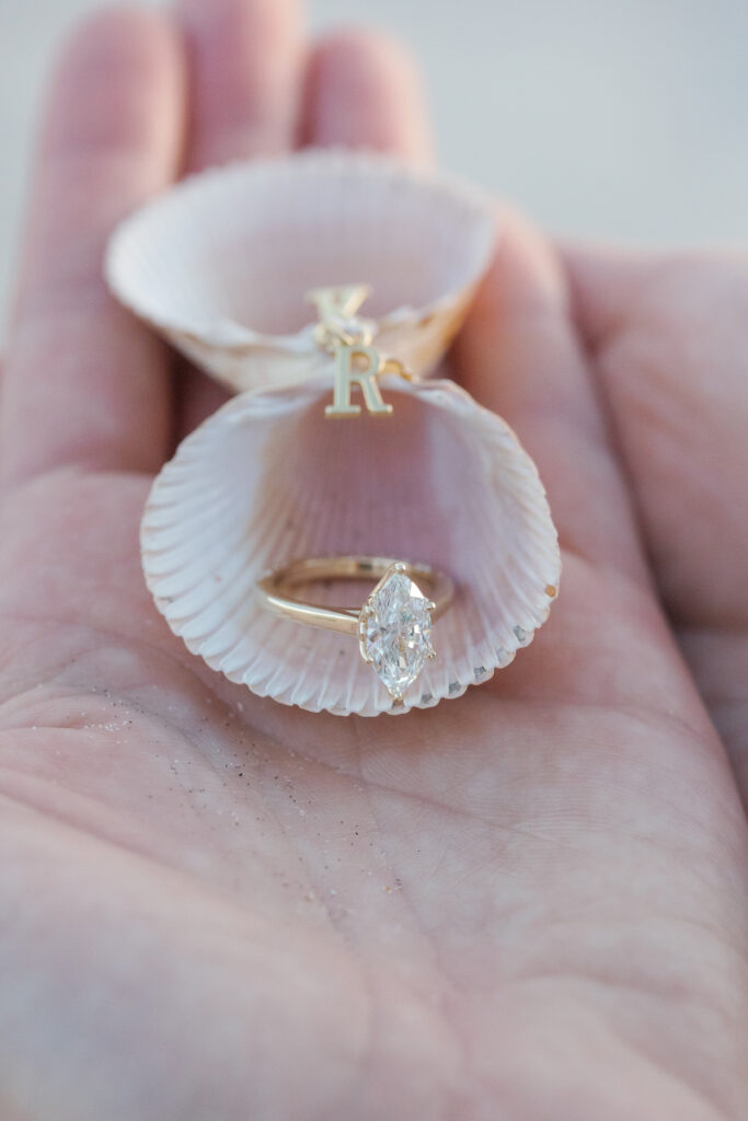 Handmade seashell engagement ring box holding the ring during a beach proposal