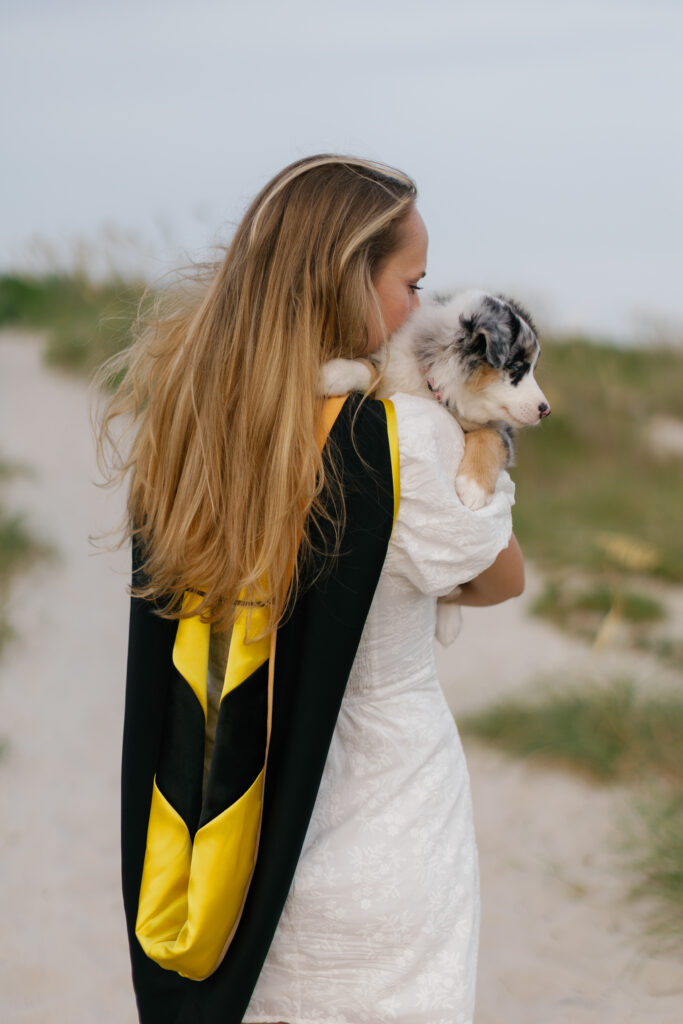 Graduate holding her puppy during senior photos on the Crystal Coast