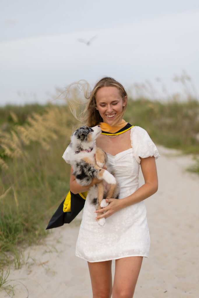 Atlantic Beach graduation photos with graduate and her puppy near the dunes